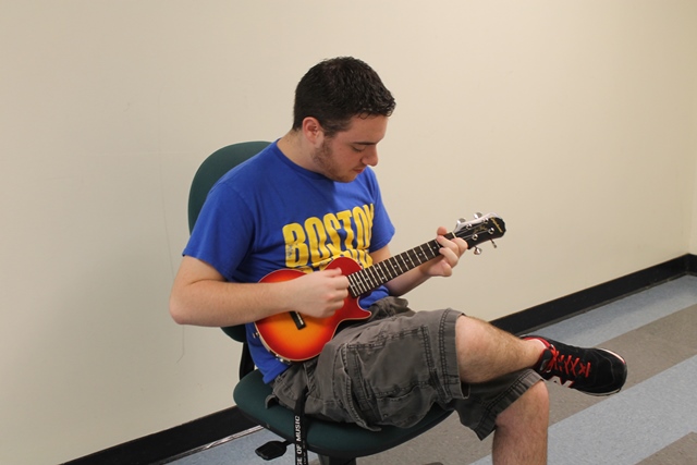 Senior Brian Roman strums away on his ukulele. 