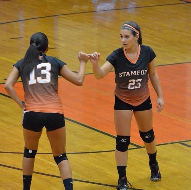 Seniors Nicole Pease and Briana Aries wishing each other luck mid-serve. 