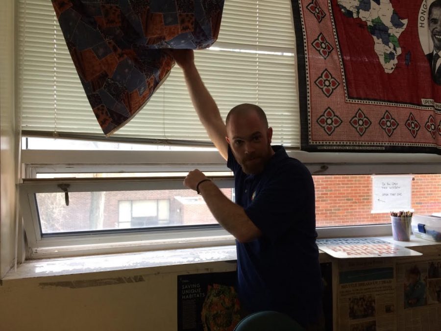 Journalism teacher Jon Ringel points down to the area where he saw the hawk eating squirrels for an entire school day.