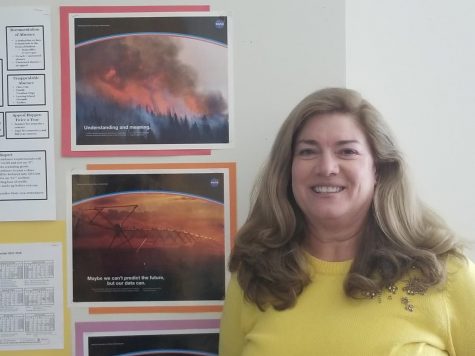 Science Teacher Sue Dougherty poses next to NASA artwork in her SHS classroom.