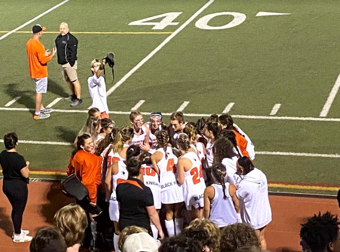 Field hockey team huddles during time out